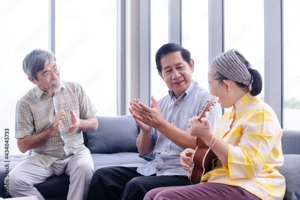 Obraz premium group of asian retired grandparent enjoy sing a song in living room