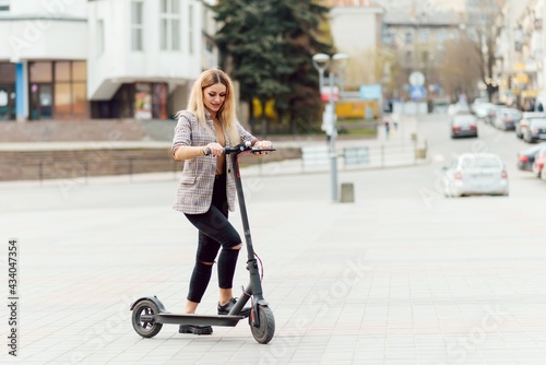 Girl in electric scooter riding in the old city center