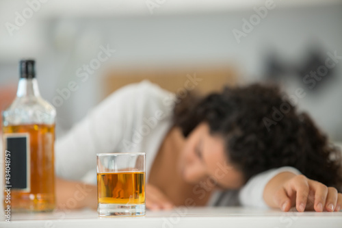 drunk woman with a bottle and a glass of whisky