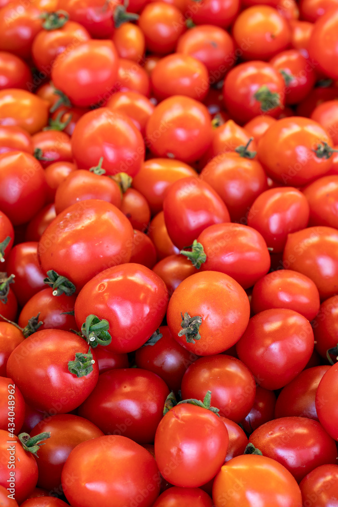 fresh cherry tomatoes in the market. cherry tomatoes in bulk. ripe cherry tomatoes in a street market