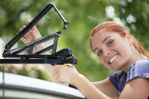happy woman installing a roof rack photo