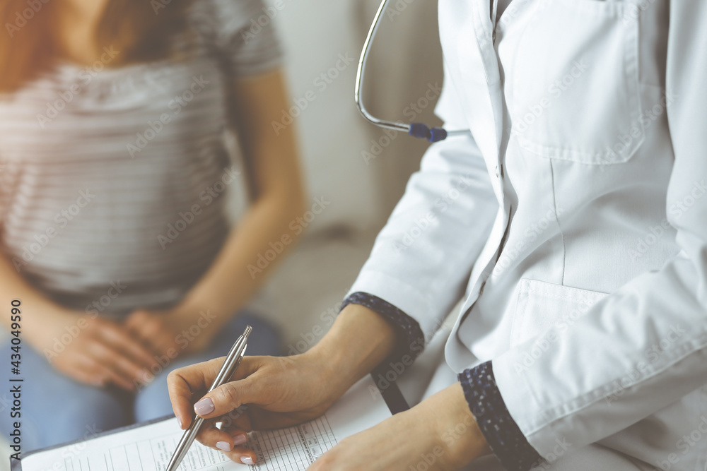 Fototapeta premium Close-up of woman-doctor and patient discussing current health examination while sitting indoors. Stay at home concept during Coronavirus pandemic and self isolation quarantine. Covid 2019