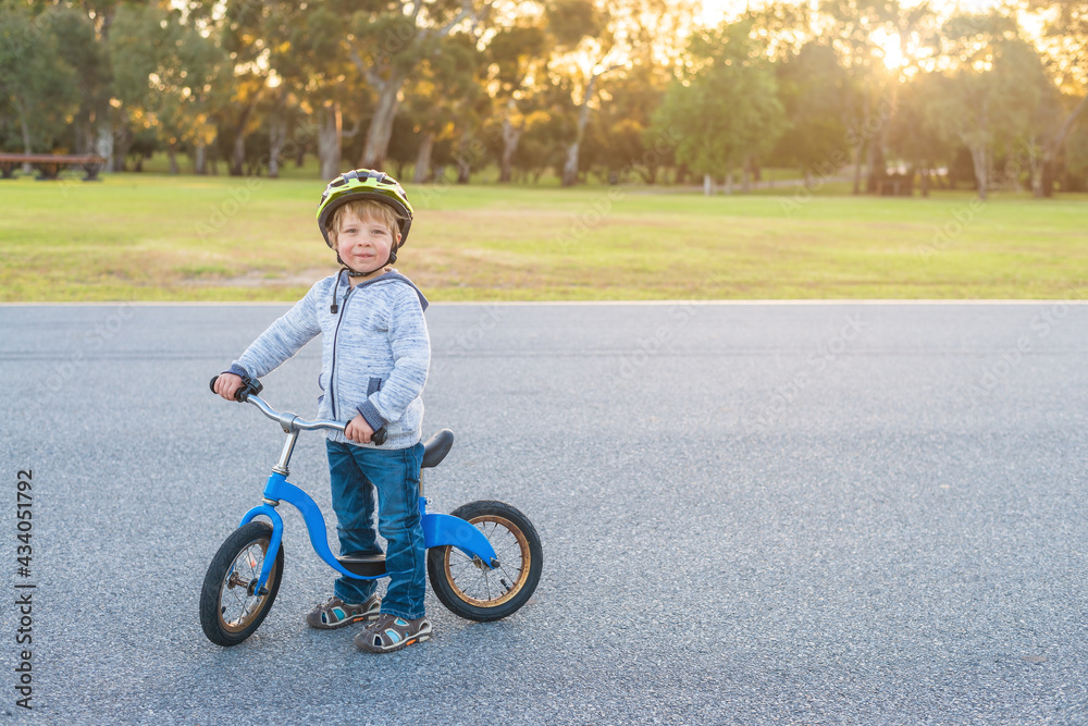 Boy riding his balance bike at sunset in Adelaide Park Lands, South Australia Boy riding his balance bike at sunset in Adelaide Park Lands, South Australia
