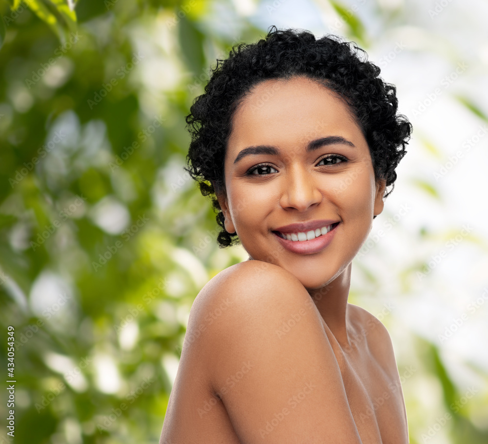 beauty and people concept - portrait of happy smiling young african american woman with bare shoulders over green natural background beauty and people concept - portrait of happy smiling young african american woman with bare shoulders over green natural background