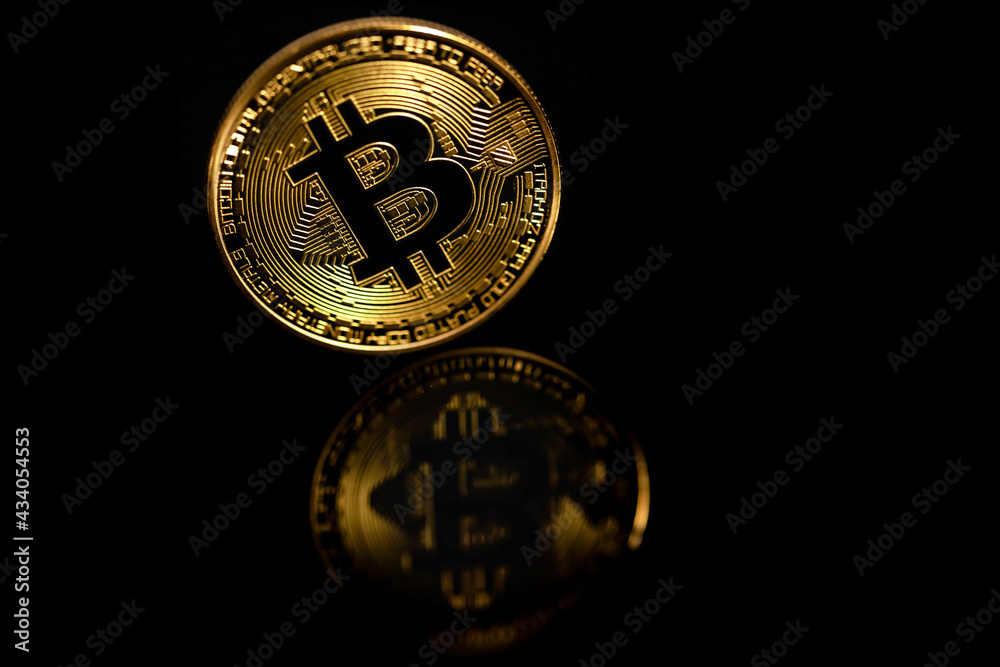 Closeup golden bitcoin with reflection isolated on black background. Bitcoin is reflected in the mirror. Closeup golden bitcoin with reflection isolated on black background. Bitcoin is reflected in the mirror.