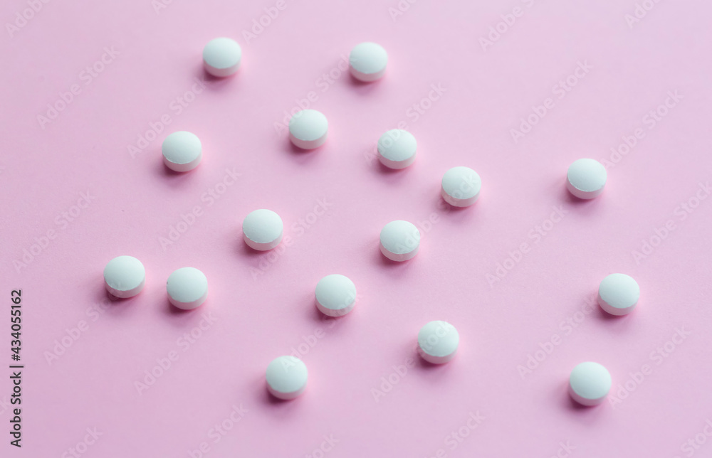 White pills on a blank colored background. Medicines, vitamins, treatment and pharmacology concept White pills on a blank colored background. Medicines, vitamins, treatment and pharmacology concept