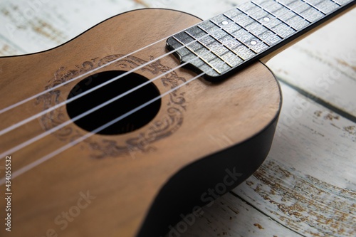 
Wooden ukulele on a light background close up