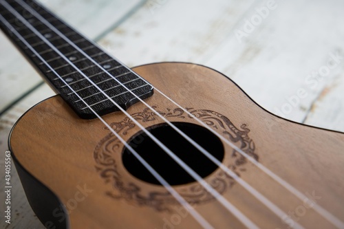 
Wooden ukulele on a light background close up