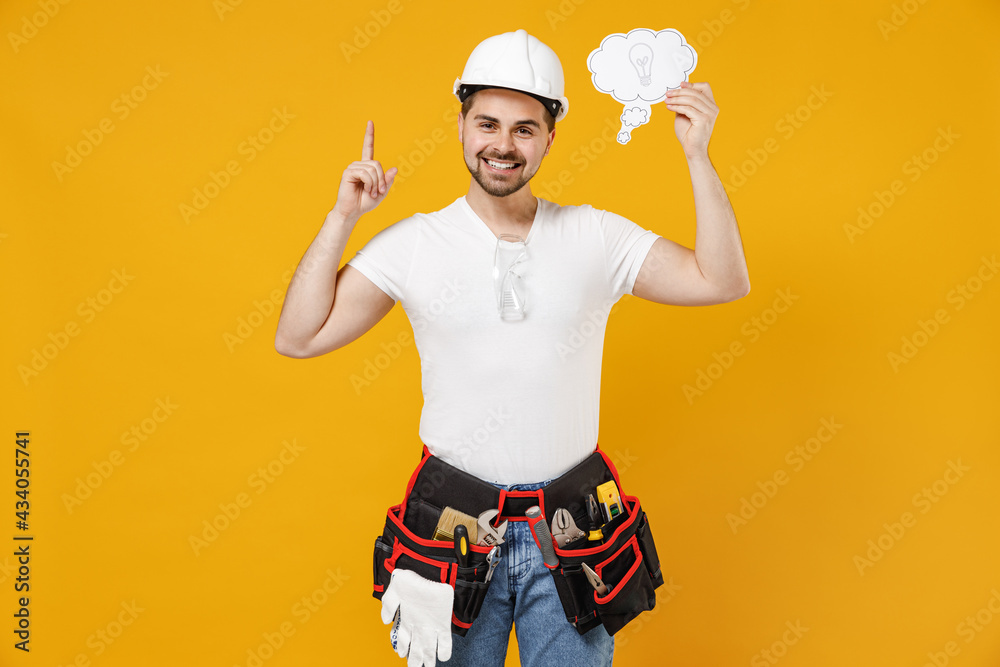 Young employee handyman man in protective helmet hardhat hold say cloud with lightbulb point finger up new idea isolated on yellow background Instruments renovation apartment room Repair home concept Young employee handyman man in protective helmet hardhat hold say cloud with lightbulb point finger up new idea isolated on yellow background Instruments renovation apartment room Repair home concept