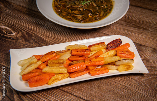 Chicken Hunter recipe with glazed root vegetables, carrot, turnip with its mushroom sauce deglazed in white wine and wet with the chicken stock photo