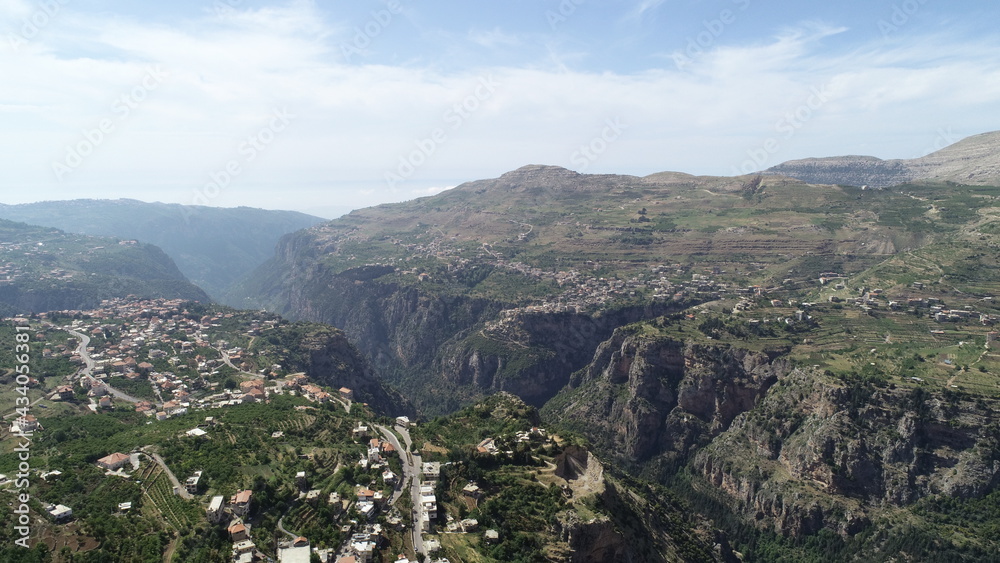 Beautiful village near the valley. Aerial image of the city and valley. Best hiking trails. Middle East country. Summer vacation in Lebanon. Travel trip. Village from bird's eye view