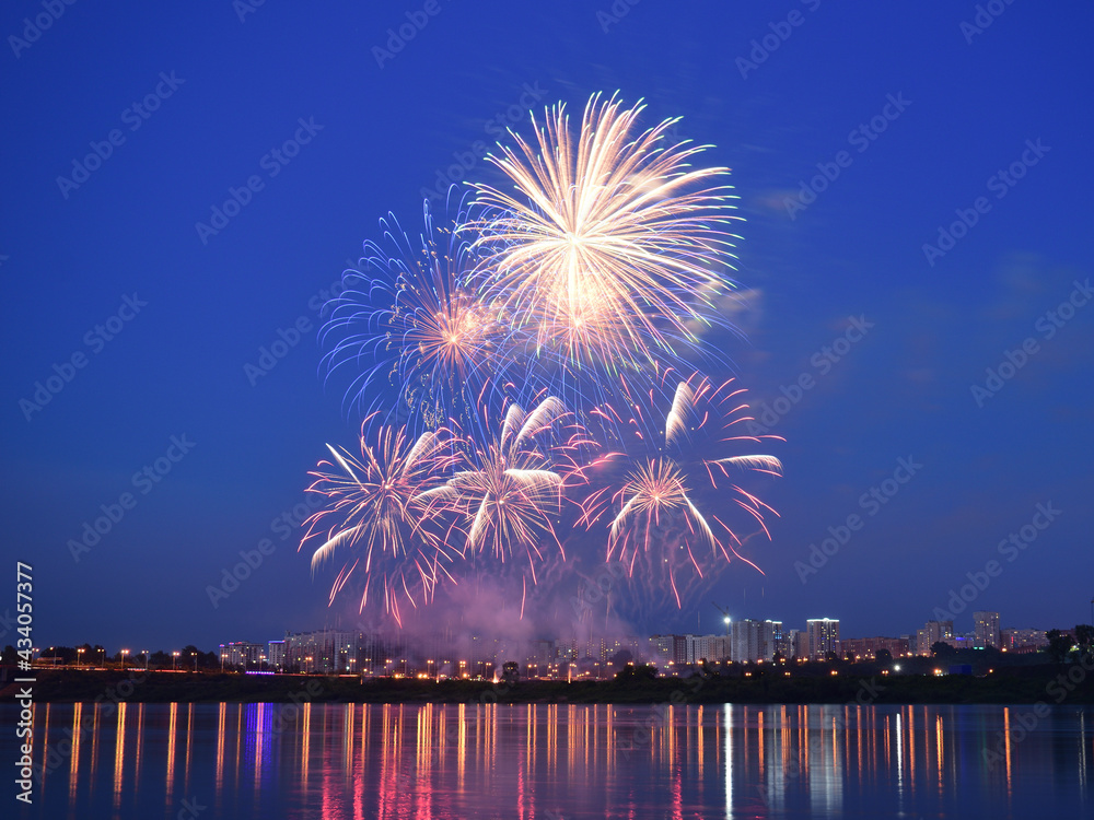 Fireworks show in city. Fireworks are reflecting in the water. Fireworks show in city. Fireworks are reflecting in the water.
