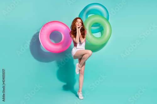 Full length body size view of pretty cute girl posing pout lips rubber rings flying isolated bright blue color background © deagreez
