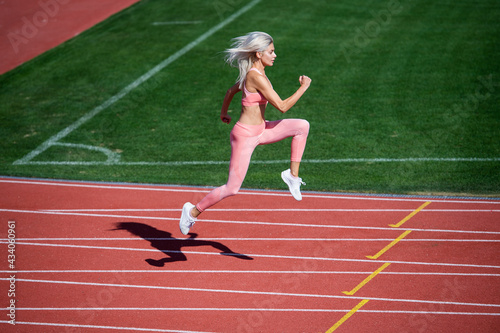 Never give up. marathon. energetic and sporty. sexy fitness woman in sportswear. athletic lady run on stadium running track. female athlete ready for sprint sport workout. trainer or coach training