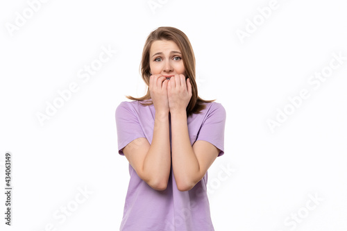 Shocked young woman covering her mouth with hands, isolated on white background