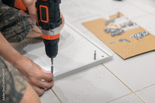 Wallpaper Mural Closeup of hand using cordless drill for assemble cabinet furniture,Do it yourself concept. Torontodigital.ca