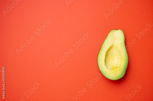 Half avocado over a red background