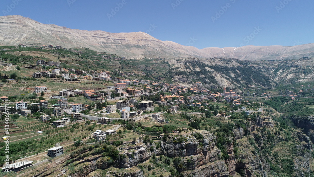 Lebanese village near the valley. Aerial 4k footage of the city and valley. Best hiking trails. Middle East country. Summer vacation in Lebanon. Village from bird's eye view. City landscape view