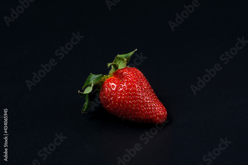 Juicy strawberries on a black background.