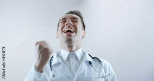 Portrait of happy doctor in surprise shoots glasses and looks at the camera in wonder and showing yes gesture