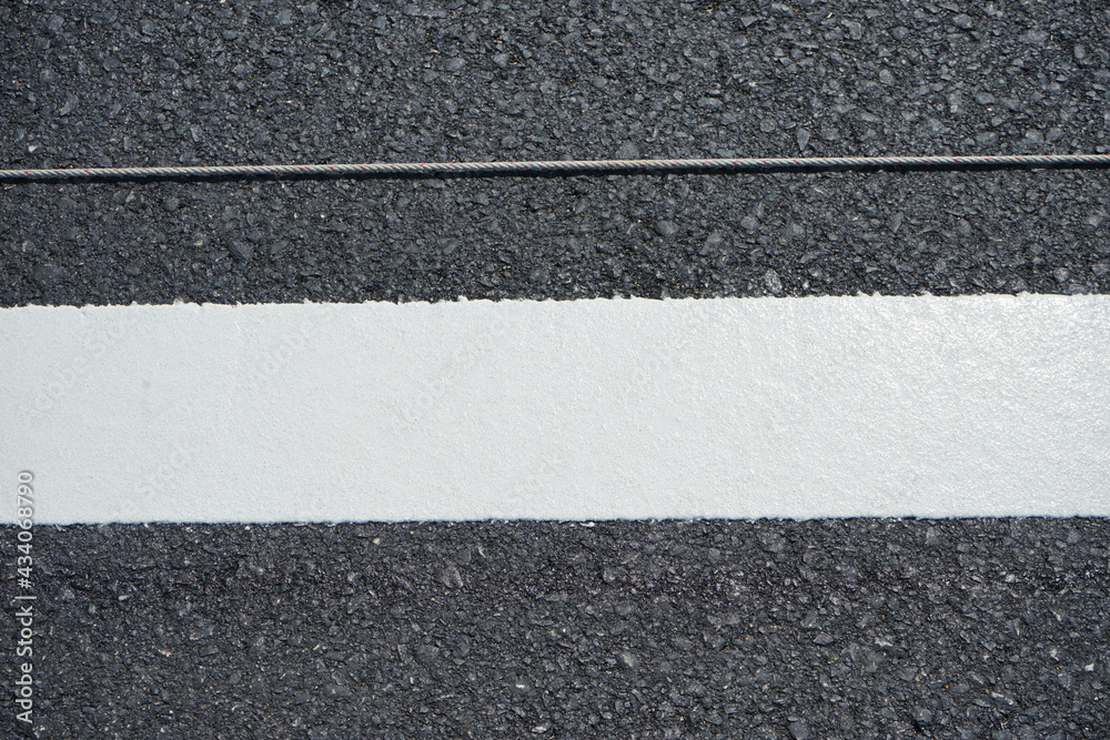 Fototapeta premium Technicians are marking a traffic line on a paved road.