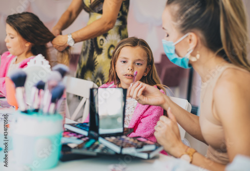 Two little girls in a make-up studio. Focus is on little girl.