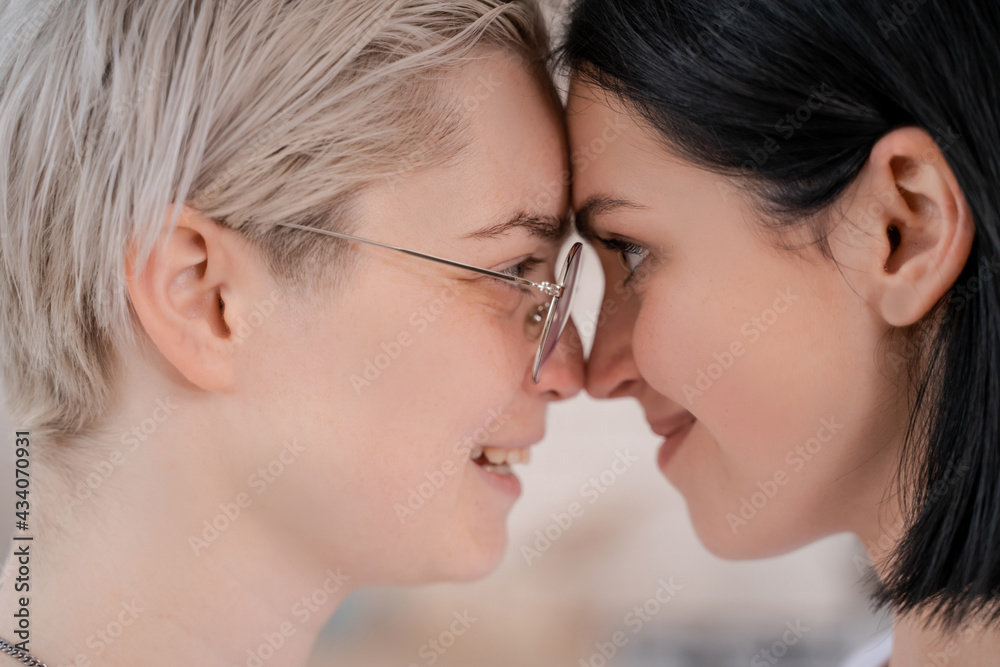 side view of cheerful lesbian couple looking at each other side view of cheerful lesbian couple looking at each other