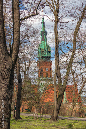 Poland Krakow, old park, catholic church in the distance, city spring landscape