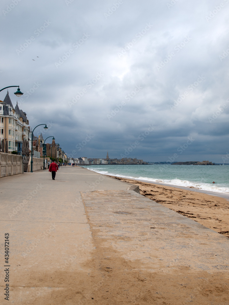 People walking along promenade at seafront in Saint Malo, Brittany, France