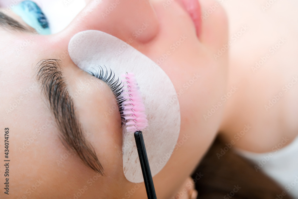 Young woman receiving eyelash lamination procedure - obrazy, fototapety, plakaty 