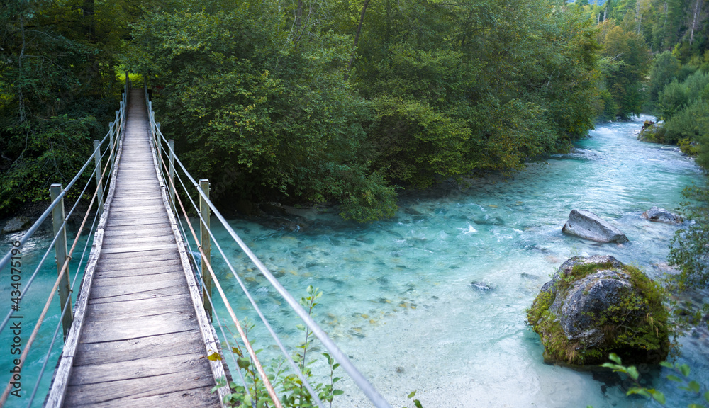 Hanging bridge over the river in the forest Hanging bridge over the river in the forest