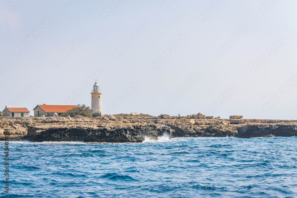 Coastline with a lighthouse and outbuildings on the coast in Cyprus