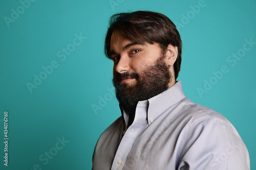 Handsome big man with beard, posing over blue background. Isolated.