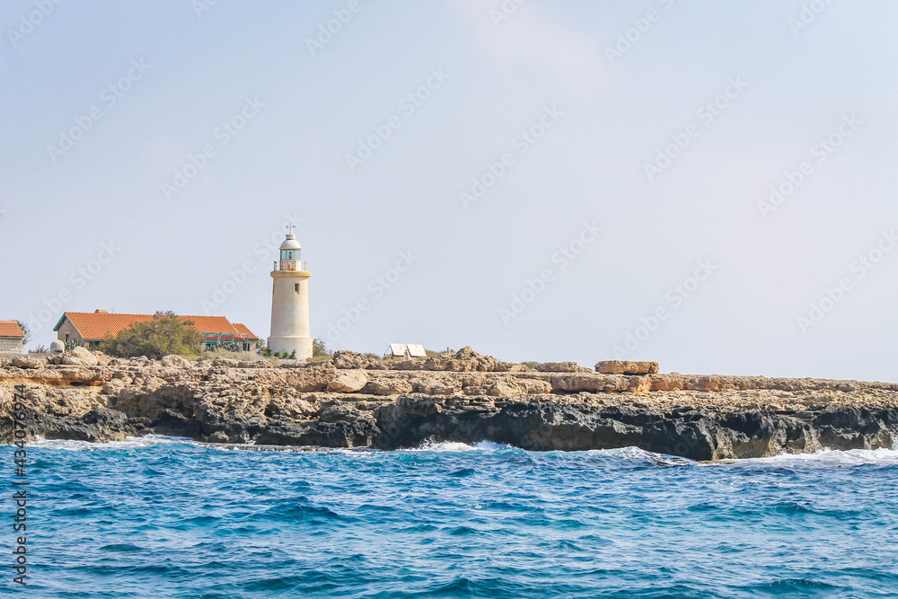 Coastline with a lighthouse and outbuildings on the coast in Cyprus