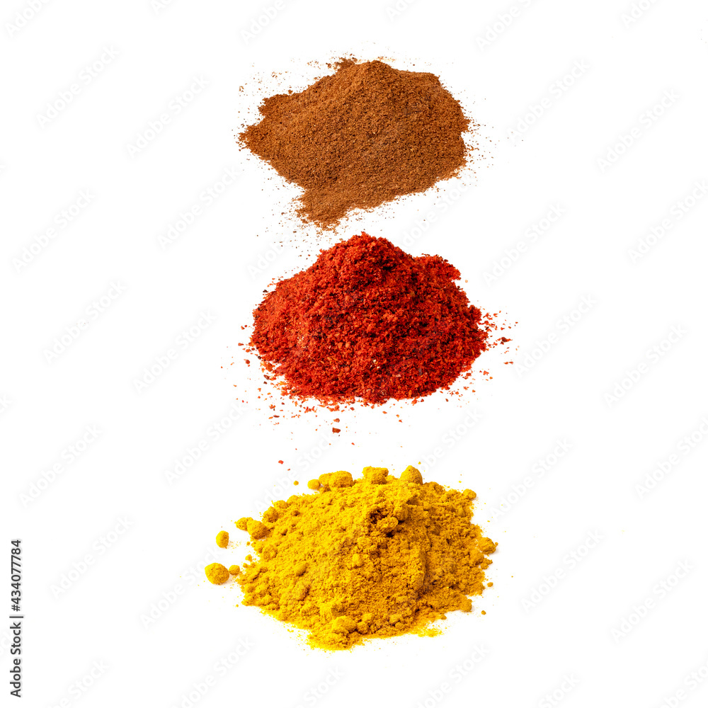 three various piles of powdered spices on white three various piles of powdered spices on white