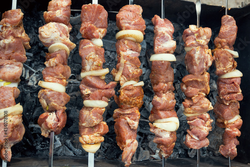 Marinated shashlik preparing on a barbecue grill over charcoal. Shashlik or Shish kebab popular in Eastern Europe. Shashlyk (skewered meat) was originally made of lamb. Roast Beef Kebabs On BBQ Grill.