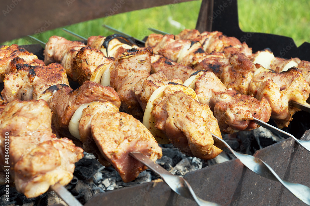 Marinated shashlik preparing on a barbecue grill over charcoal. Selective focus. Shashlyk (skewered meat) was originally made of lamb. Roast Beef Kebabs On BBQ Grill.. Marinated shashlik preparing on a barbecue grill over charcoal. Selective focus. Shashlyk (skewered meat) was originally made of lamb. Roast Beef Kebabs On BBQ Grill..
