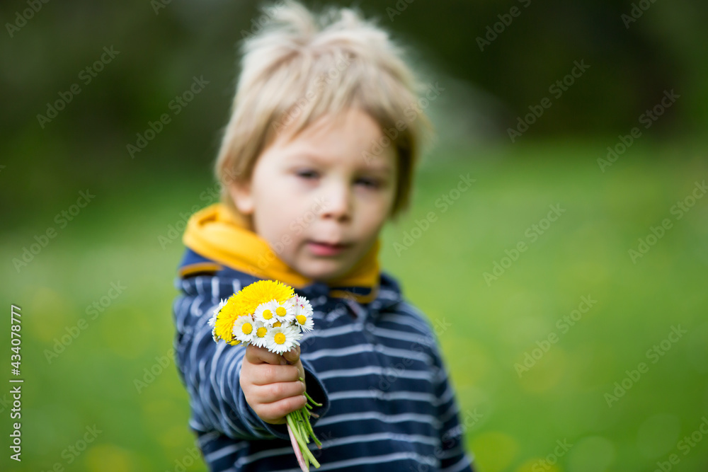 Beautiful toddler blond child, cute boy, lying in the grass Beautiful toddler blond child, cute boy, lying in the grass