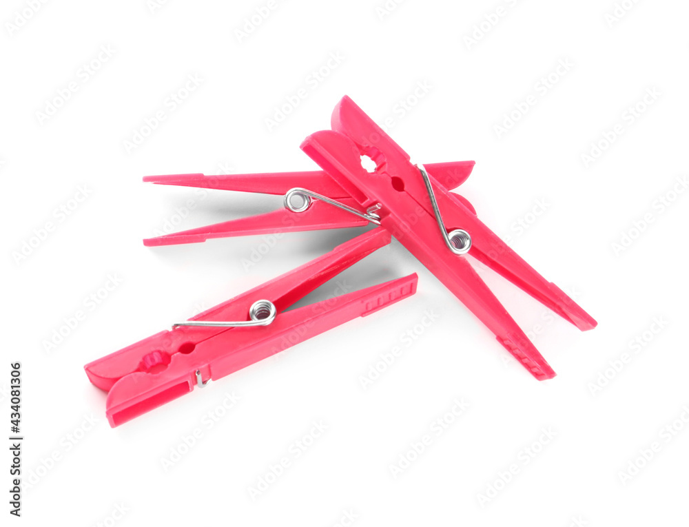 Bright pink plastic clothespins on white background, above view Bright pink plastic clothespins on white background, above view