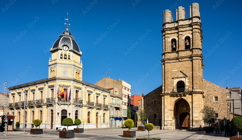 Cityscape of old town La Bañeza in Castile and Leon, Spain, with historic town hall building and landmark Saint Mary church on the main town square.