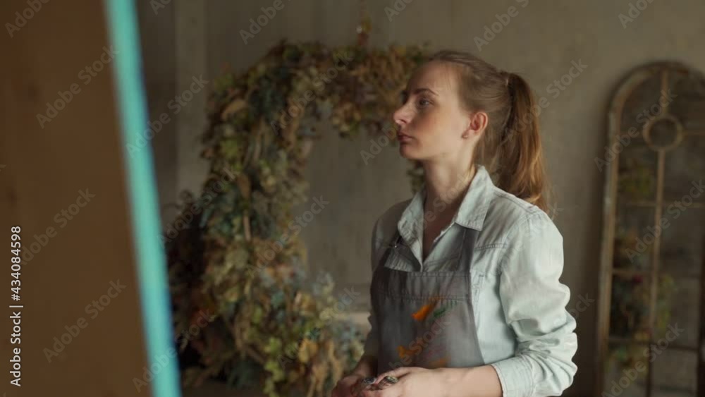 Talented female artist approaches a large canvas in an art studio to create a masterpiece Talented female artist approaches a large canvas in an art studio to create a masterpiece