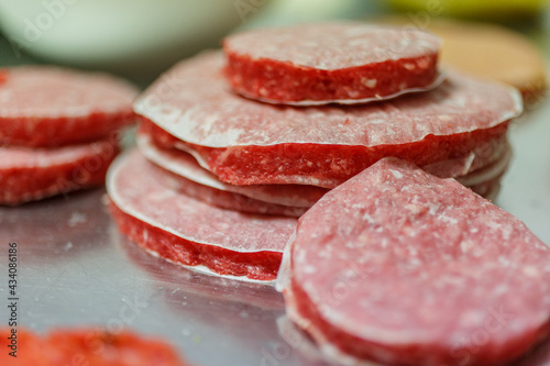 Hamburger di carne appena compattati e pressati e pronti per essere venduti o cotti photo