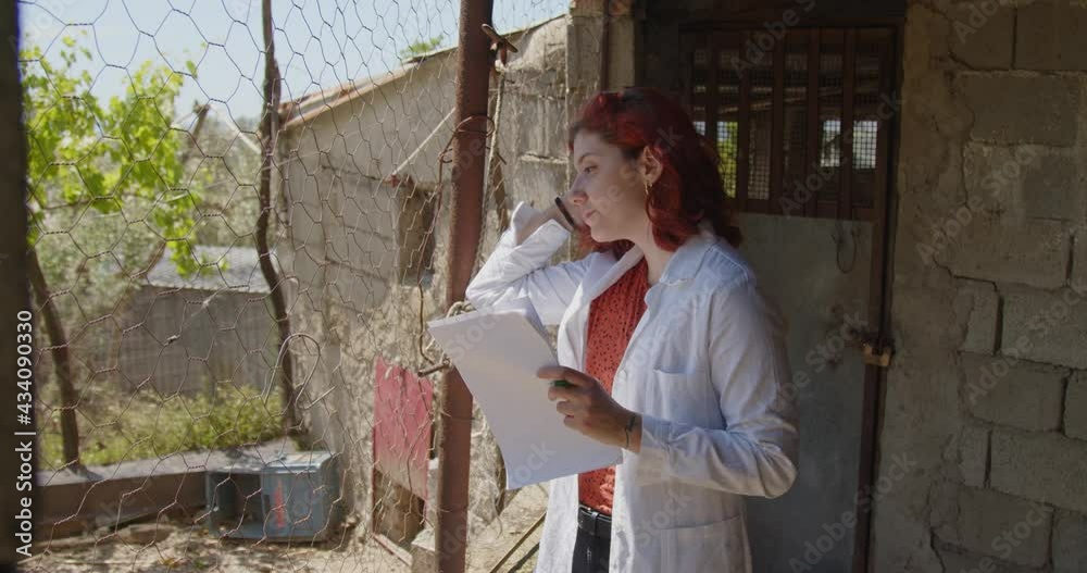 Giovane ragazza agronoma controlla le galline in un pollaio Giovane ragazza agronoma controlla le galline in un pollaio