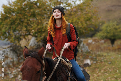 woman hiker riding a horse in the mountains travel fresh air fun