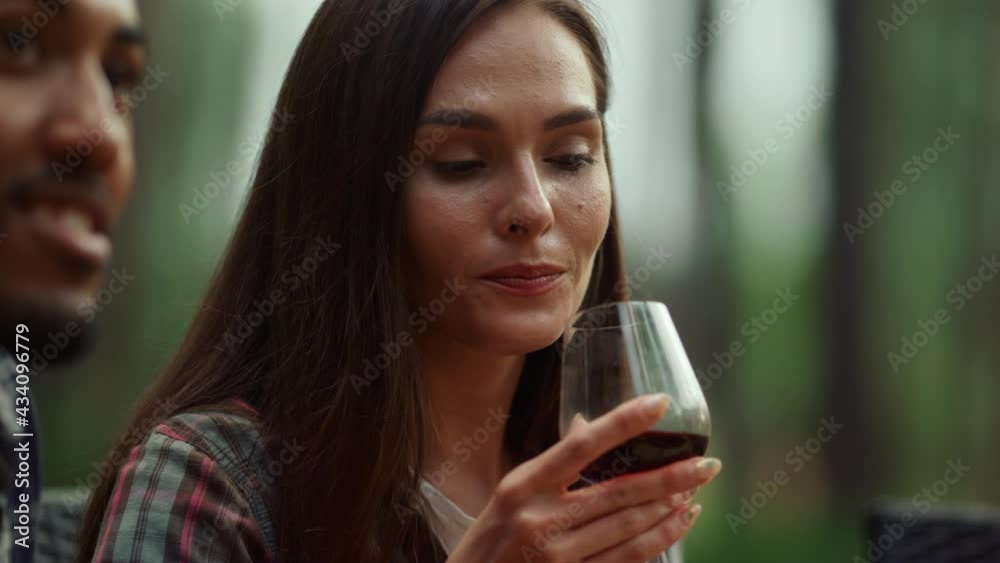 Beautiful girl resting with friends outside. Woman drinking wine on party Beautiful girl resting with friends outside. Woman drinking wine on party