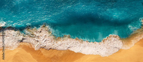 Aerial view of blue ocean waves in Kelingking beach, Nusa Penida island in Indonesia. Beautiful sandy beach with blue sea. Lonely sandy beach with beautiful waves. Panorama Beach. Copy space