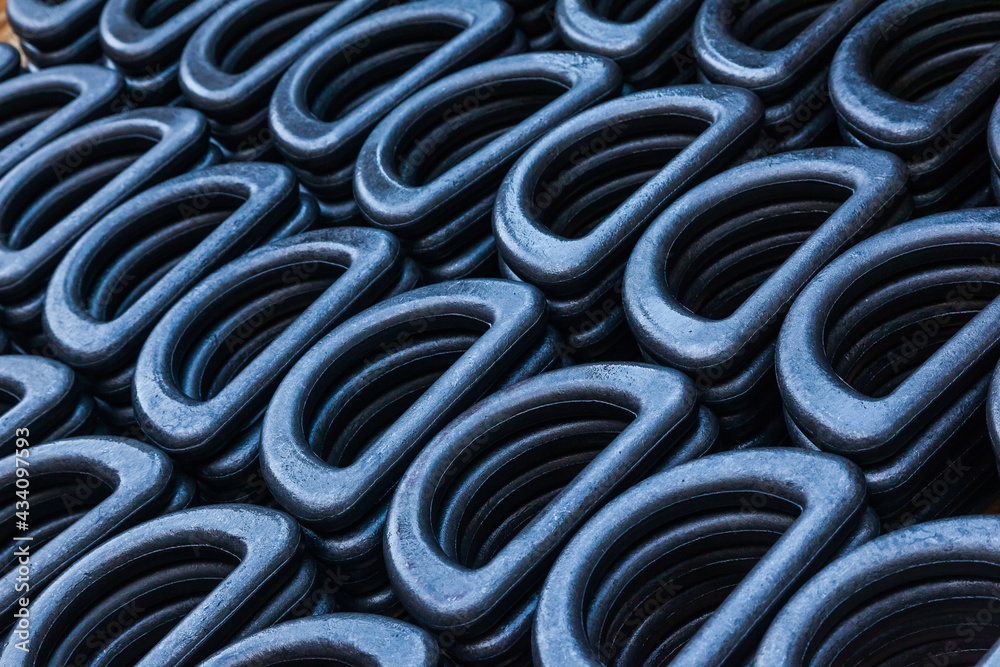 D-shaped steel rings stacked in close-up. Lots of steel rings for securing and securing heavy industrial loads. D-shaped steel rings stacked in close-up. Lots of steel rings for securing and securing heavy industrial loads.