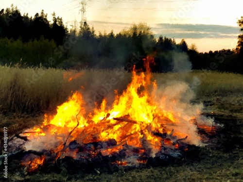 A large bonfire on the edge of the forest celebrates the arrival of spring.