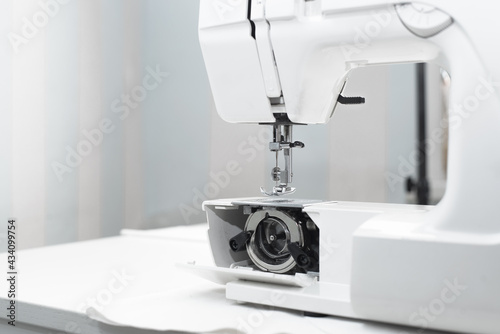 Part of a white professional electric sewing machine, close-up. Internal mechanism of sewing equipment. Repair, maintenance and service