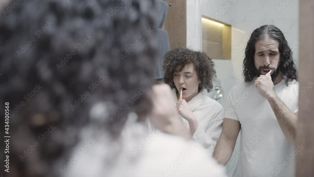 Young husband and wife brushing teeth in the morning together, self care routine Young husband and wife brushing teeth in the morning together, self care routine